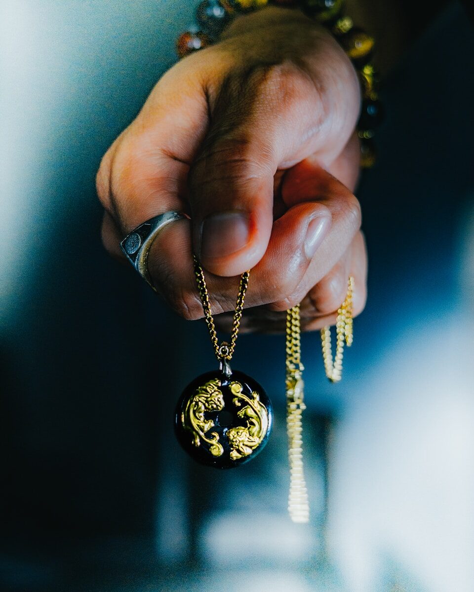 a person holding onto a necklace with a dragon on it